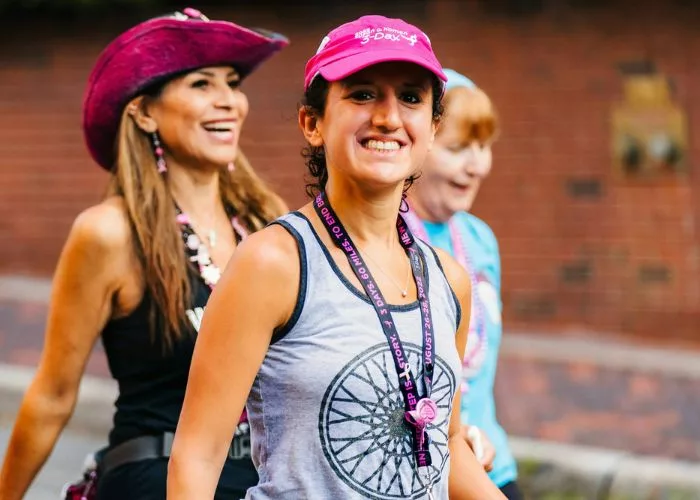 Three women prepare to participate in a walk-a-thon to raise awareness for cancer research.