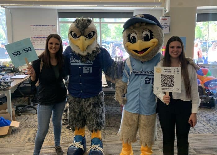Members of Launch57 posing with the Riverhawks mascots