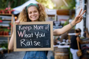 Fundraising admin holding up a sign that says "Keep More of What You Raise"