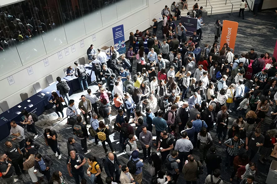 A local fundraiser held inside a convention center which has a large crowd of attendees.